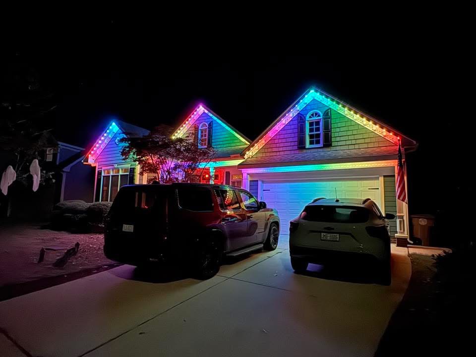 Single story home with 3 peaks showing permanent LED lighting casting rainbow colors onto front facade
